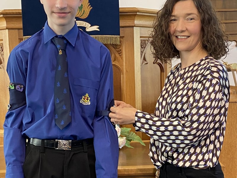 Callum having his badge pinned on by his mum Jennifer.