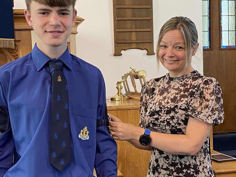 Daniel having his badge pinned on by his mum Paula.