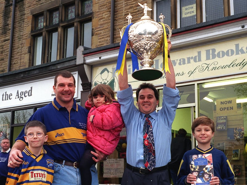 Author of Headingley Rugby Voices Phil Caplan holds aloft the Silk Cut Challenge Cup at the opening of Philip Howards Books on Street Lane in October 1999. He is watched by Leeds Rhinos forward Marc Glanville who opened the shop and some local children Oliver Munden, left, Christopher Collins and sister Rebecca.