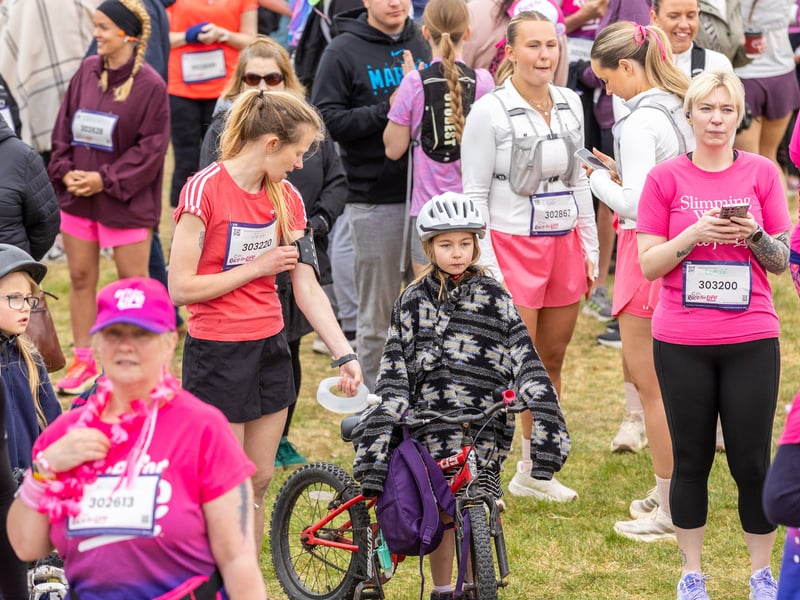 A youngster brings a bike to the 10k start 