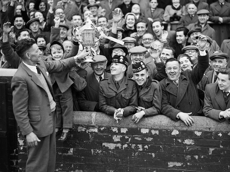 Hearts groundsman Mathie Chalmers shows the Scottish Cup to a section of the crowd at Tynecastle in 1956 after Hearts had beaten Celtic at Hampden Park in the final.