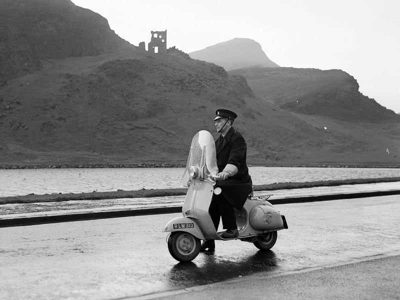 Park Keeper Thomas Wilson patrols on his scooter next to St Margaret's Loch with St Anthony's chapel and Arthur's Seat in the background.