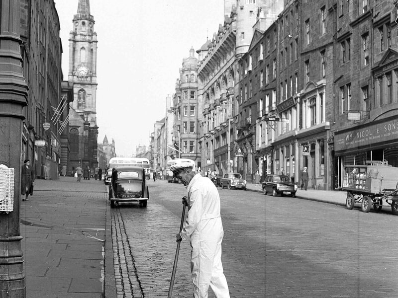 A street orderly in a white uniform, using an old besom broom on the Royal Mile in 1956.
