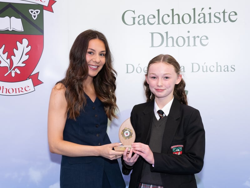 Year 10 pupils sit GCSE Irish but not all of them attain a 100% in the exam. Year 10 pupil Alice did just that and received her prize from Caitríona Nic an tSaoir.