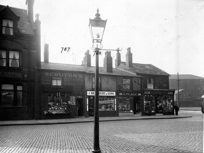 Bensons Place, a cobbled street off Belle Isle Road, pictured in  December 1935. The Bay Horse Hotel, Wilfred Gavins greengrocers, J. Bradbury and Sons pork butchers, Arthur Place boot and shoe maker, Arthur James Hawkes draper and the Cooperative Wholesale Society Brush factory are shown.
