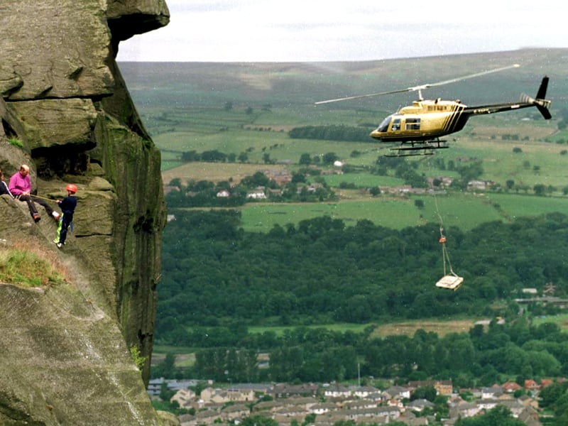 A helicopter begins to task of carrying stone slabs to the top of the moor at the Cow & Calf. The stone wasbeing used to create footpaths to halt errosion caused by visitors.