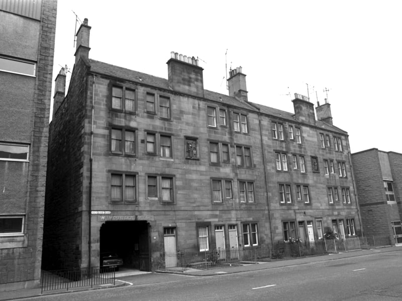 A row of tenements on Holyrood Road, next to the Harp lager brewery, in September 1980. The walls have carvings of a glass-blower and a bottle-maker.