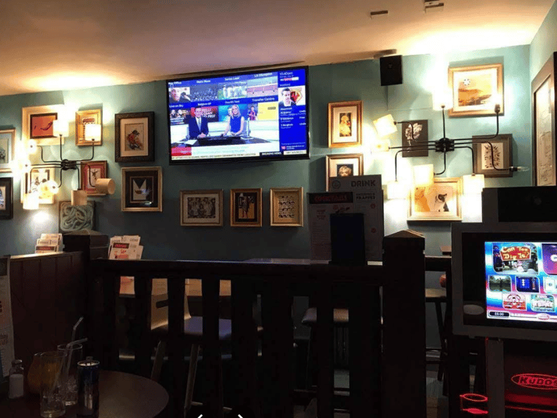 Modern bar with banquettes, framed pictures and screens showing live sports. It also offers an excellent bottomless brunch.