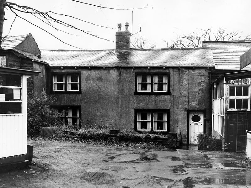 Tower Lane in November 1963. The property has a pebble dashed finish with black painted window and door surrounds. On the right edge is part of the Tower Lane Garage. On the left is a white painted kiosk, possibly where the petrol pump attendant would have sat.