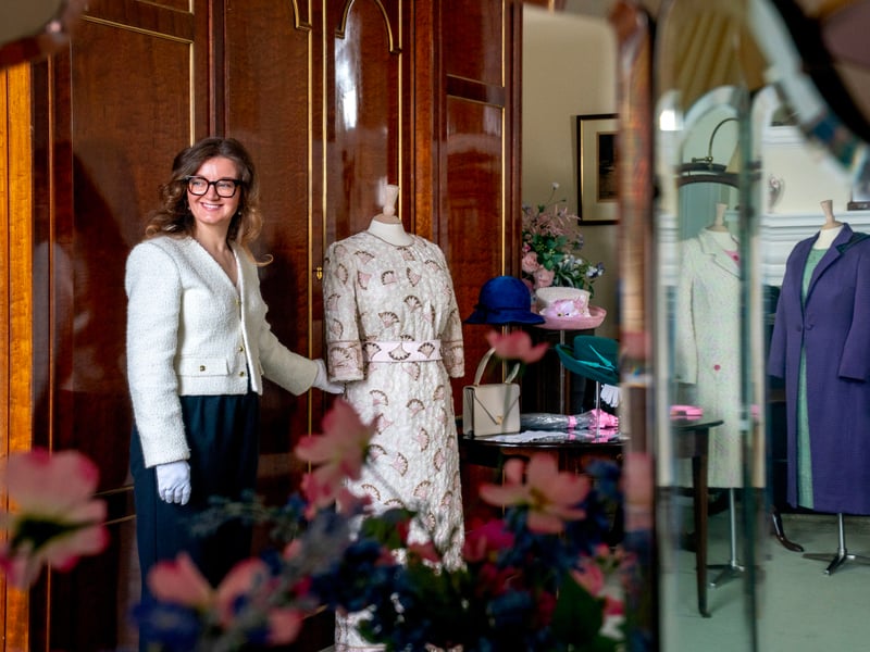 A member of staff from the Royal Trust Collection alongside a silk evening dress designed by John Anderson and worn by the late Queen Elizabeth II for the Commonwealth Heads of Government reception held in 1997, at the Palace of Holyroodhouse in Edinburgh, the official residence of the monarch in Scotland.