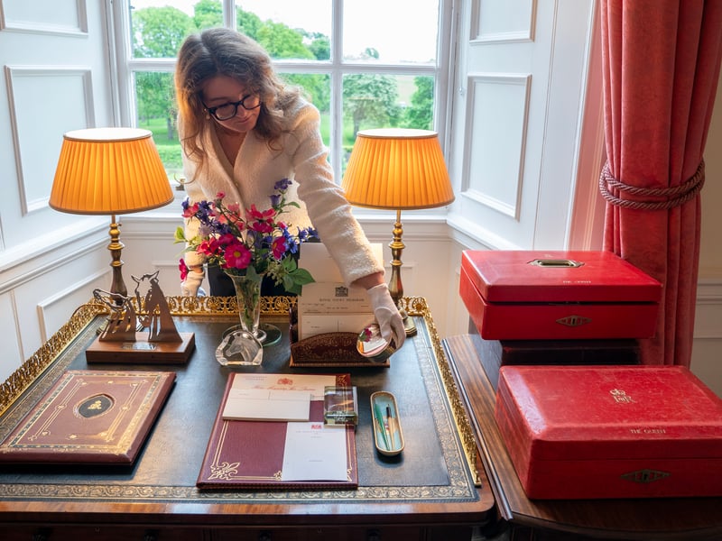 A member of the Royal Trust Collection staff arranges items on the desk in the Sitting Room where the late Queen Elizabeth II would work, reviewing the papers and documents presented in the Government red dispatch boxes, at the Palace of Holyroodhouse in Edinburgh, the official residence of the monarch in Scotland. 