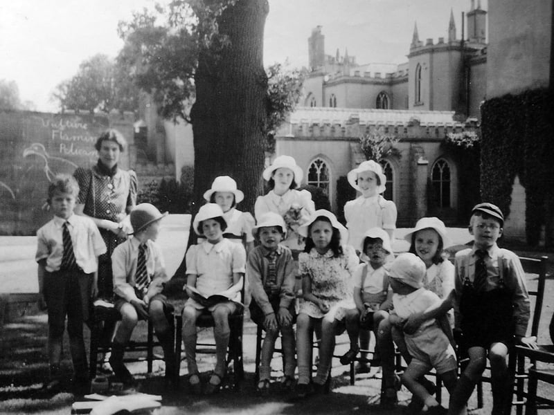 Evacuee pupils from St Helena’s School, evacuated from Eastbourne during the Second World War, are pictured taking an outdoor lesson in the grounds of Combermere Abbey near Whitchurch in 1943. With a teacher and classmates gathered beneath the trees, the children learn in the sunshine as part of wartime life at the historic country house.