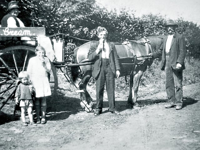 This picture was shared by Basil Morris of Prees, this charming 1933 photograph was taken outside 1 Pound Lane, Stottesdon, and shows his grandmother Sarah Morris on her homemade ice cream cart. On the right is her husband John Morris, while young Basil, born in 1931, stands on the left in shorts. Beside him are Edna and Jack, daughter and son of Sarah and John Morris. A lovely glimpse of village life and summer days from more than 90 years ago.