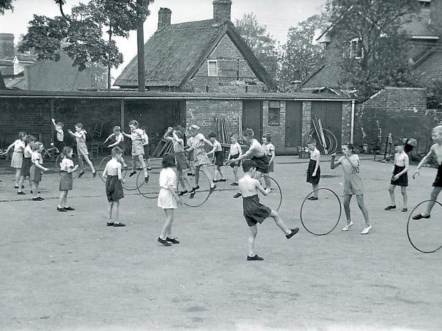 Children enjoy a game of hoopla during a physical education lesson at an unidentified Shropshire junior school, believed to have been photographed in the late 1940s or early 1950s.