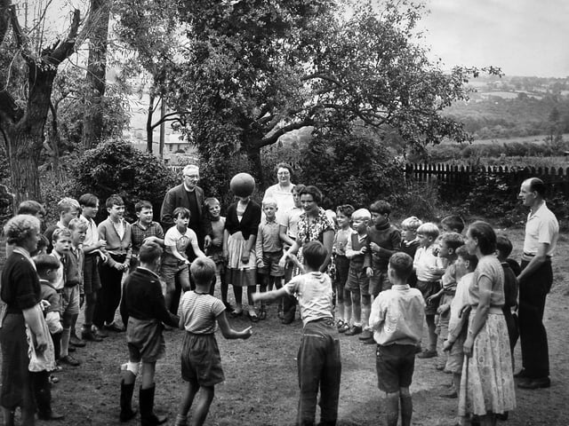 Rev R G Miles, Vicar of Highley, is pictured in 1957 with children from East London enjoying a countryside break through the Children’s Country Holiday Fund. 