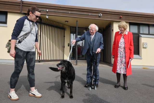 Michelle Bermingham and her dog Chalky greet President Michael D Higgins and his wife Sabine Higgins at the polling centre in Westside.