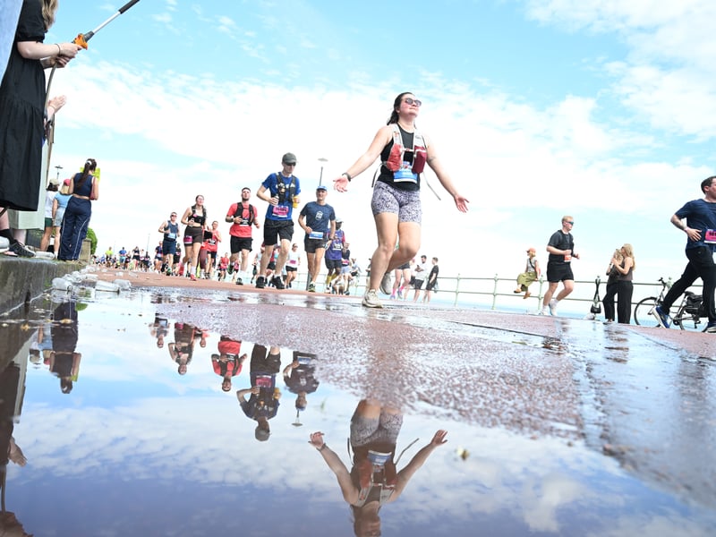 Runners' reflections fill the puddle during the marathon.