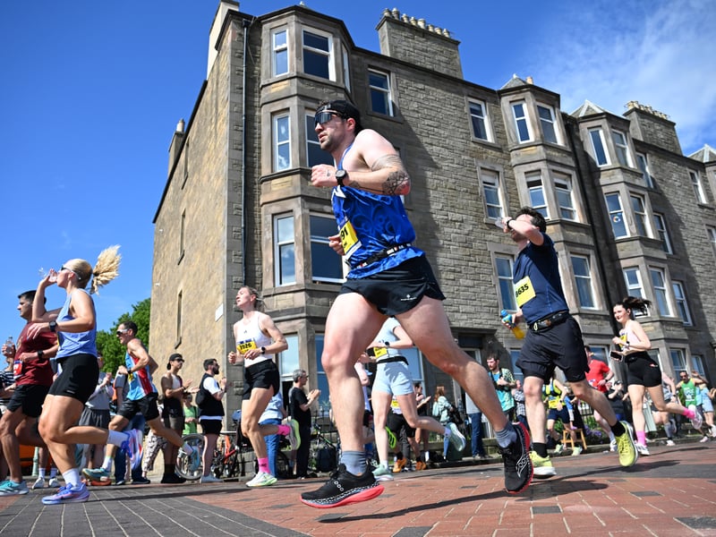 Some runners take on supplies as they head through Scotland's capital city.