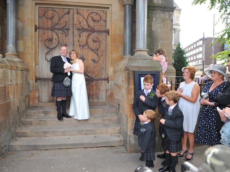 Friends and family look on as Deputy First Minister Nicola Sturgeon and Peter Murrell pose outside Glasgow's Oran Mor where they were married on July 16, 2010.