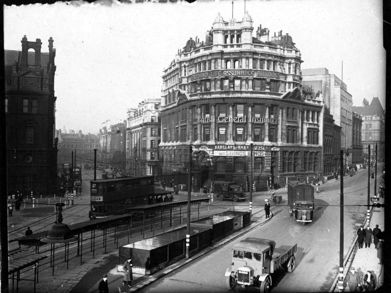 Looking north at the point where Infirmary Street, on the left, and Park Row, on the right, meet City Square. At the junction is The Standard Building which houses; Standard Life Assurance Co., British General Insurance and Barclays Bank Ltd. On the left is the General Post Office. Pictured in December 1943.