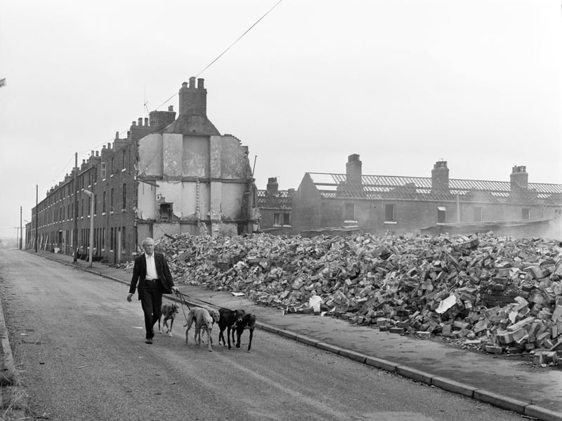 A man and his dogs walk past a demolition site on Altofts Long Row, Wakefield, in August 1979