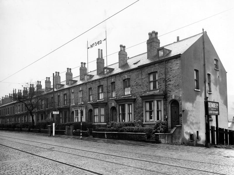 A row of terraced houses from 338 (end house on right) to 360 Meanwood Road. Number 342 is labelled. A sign for Dermide Ltd. leather cloth manufacturers is on the right. A tram stop and pillar box can be seen and there are tram lines in the road. Pictured in November 1946.