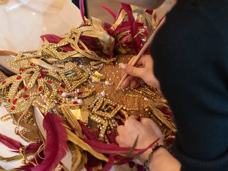 A dressmaker sticks individual crystals onto a designer dress in the shopping village at Blackpool Dance Festival. Photo: Lucinda Herbert