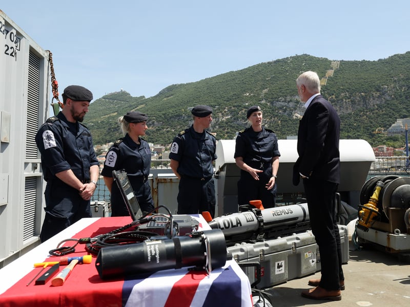 Minister of Armed Forces Alistair Carns DSO OBE MC MP getting a brief from a member of the embarked squadrons on RFA Lyme Bay.