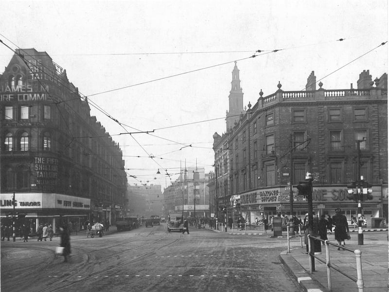 Looking west along Boar Lane from Duncan Street, across the junction of Briggate and Lower Briggate. Tramlines and overhead power cables cross at the junction. The modern frontage of Saxone Shoes is on the right. Pictured in March 1943.