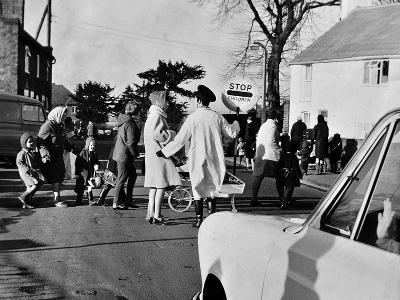 Lollipop warden held high, mothers and children safely cross the busy road outside Wrockwardine Wood County Infants' School in January 1969. The photograph accompanied a campaign led by local mother Liz Butler of Trench, who voiced fierce concerns over road safety for young pupils. The picture captures a classic late-1960s scene of headscarves, warm winter coats, and community determination as local parents fought to protect their little ones on the daily school run. Do you remember the road safety campaign at Wrockwardine Wood Infants' in 1969, or can you spot yourself wrapped up warm for the school run?