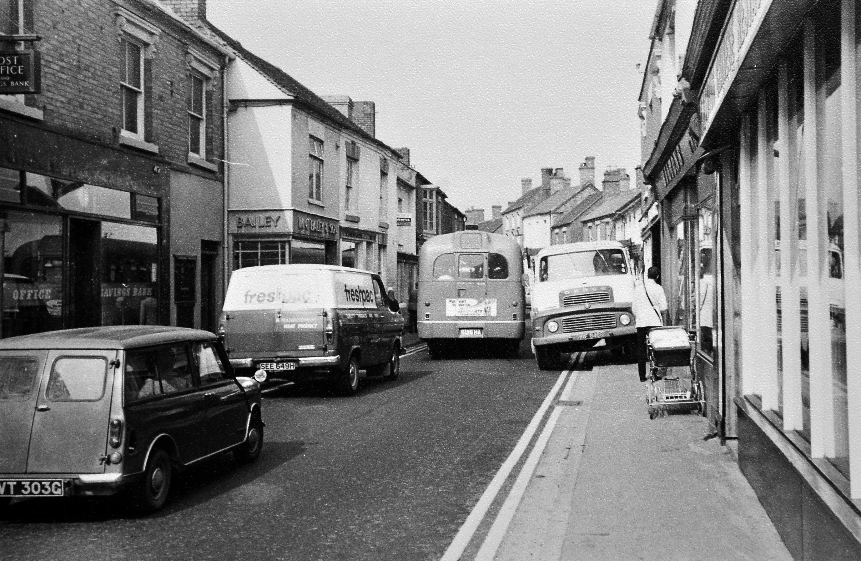 A Midland Red bus is pictured squeezing through Dawley High Street in the 1970s, highlighting how narrow the road once was before any bypass was built. The image, supplied by former bus driver Terry Humphries, shows a busy street scene with a Dodge lorry and a pram also visible. Terry recalls the bus as likely an S17 operating on the 909 route to Wellington, noting just how tight the conditions were for traffic in the town centre at the time