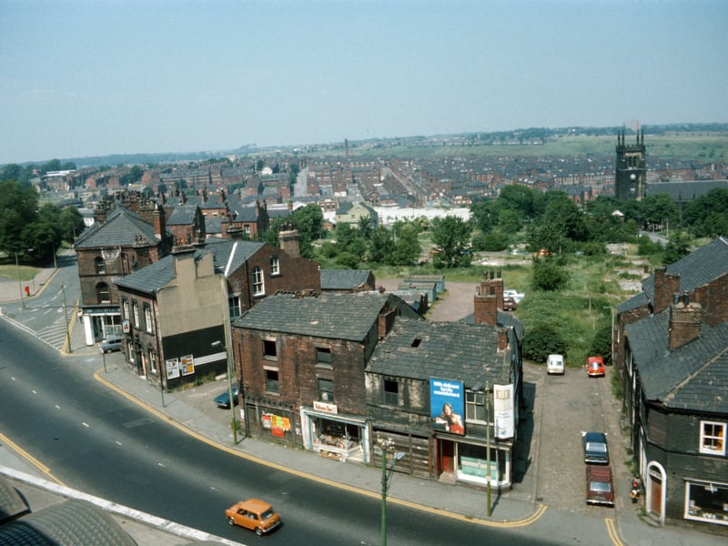 A view looking down on Woodhouse taken from Leeds University Engineering Department in JUne 1975. Woodhouse Lane runs across in the foreground, with Spenceley Street on the right and Raglan Road leading off on the left. Volume One bookshop is seen in the centre in part of a block of derelict buildings due to be demolished. To the left of this is the Pack Horse pub. St. Mark's Church is seen in the background on the right while on the far left is the corner of Woodhouse Moor.