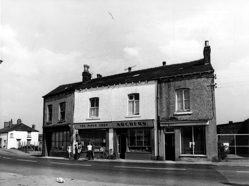 Main Street showing, from right, numbers 10-16. These include Archer's 'the paper shop' at nos. 12-14 in the centre, outside which a group of children are standing. Pictured in July 1975.