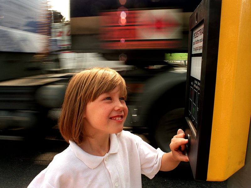 Leanne Montgomery, on her way to South Seacroft Playscheme, activates one of the new signal-controlled Pelican crossings on York Road.