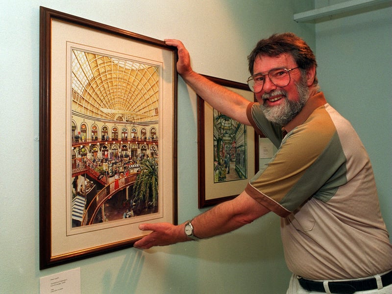 Artist Peter Lapish hangs one of his paintings at Leeds Art Gallery.