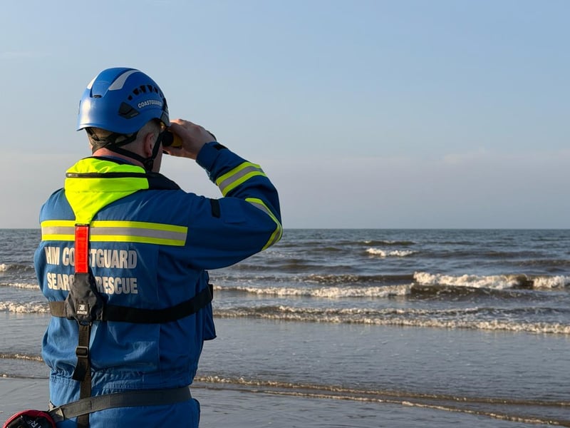 HM Coastguard personnel with binoculars.