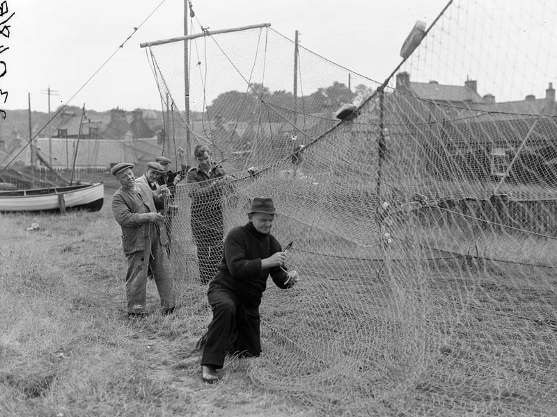 Mending fishing nets on the beach at Cromarty in November 1952.
