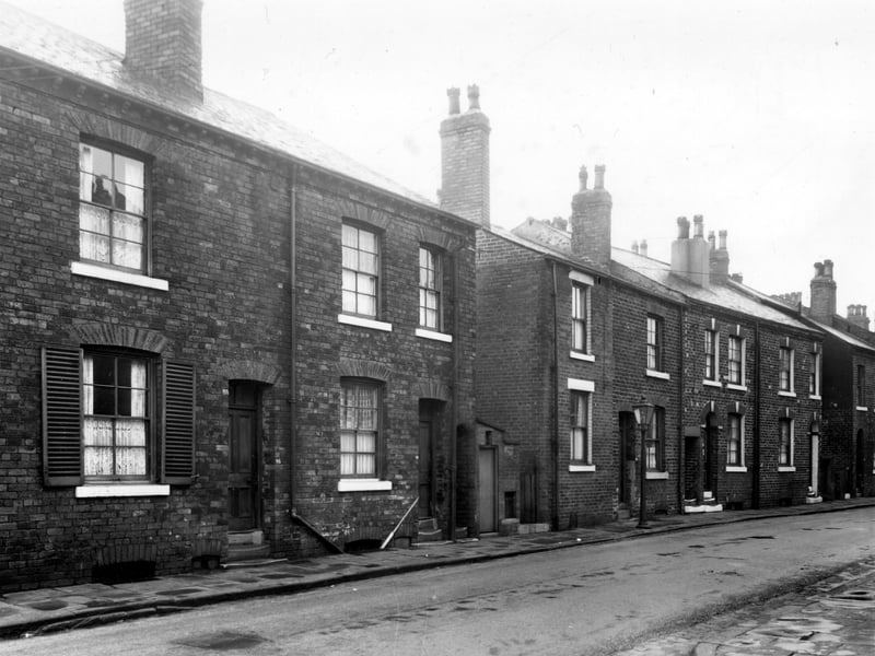 Two back-to-back terraces on Moor Crescent Road with a shared outside toilet on the right. Pictured in December 1958.