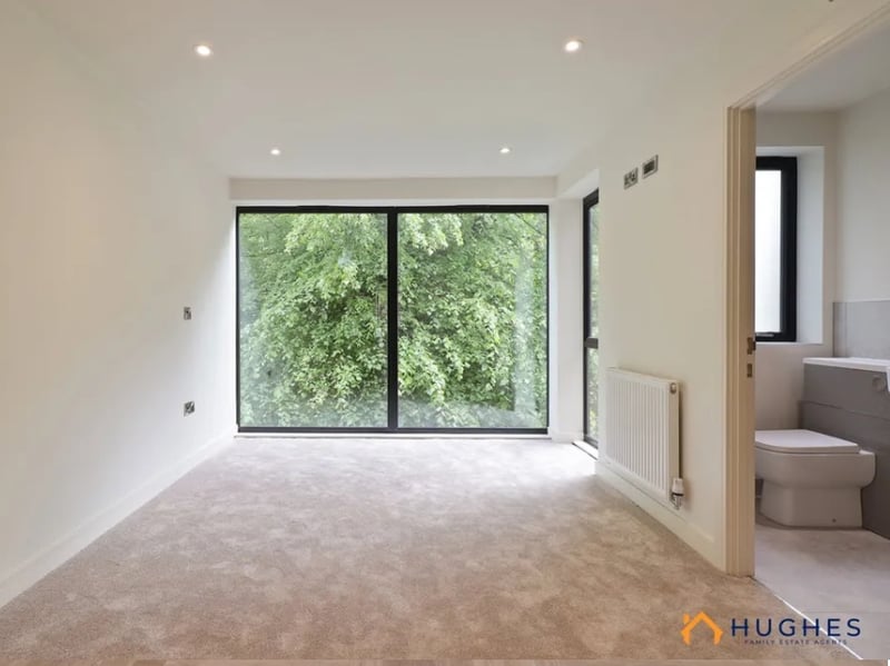 The ground floor features a balcony, the second a floor-to-ceiling window, and the top floor a roof terrace.