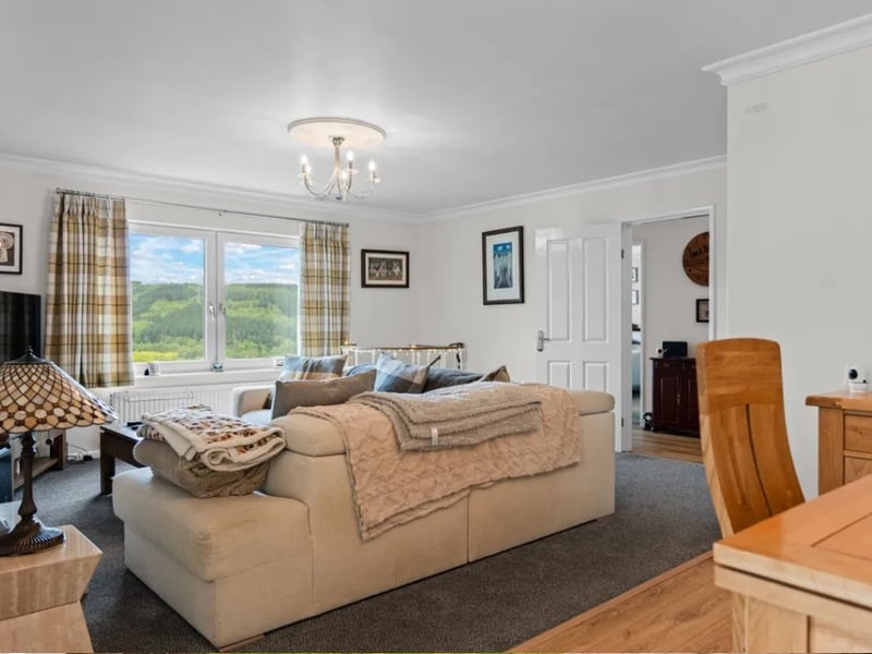 Inside, the home is a gorgeous as its garden, with generous, well-proportioned living space throughout, like this living room with an equally splendid view over the valley.
