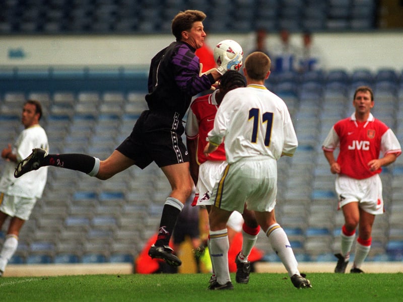 John Lukic, playing for Arsenal, takes the ball ahead of Harry Kewell.