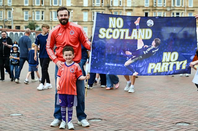 Two fans pose with a Scott McTominay flag prior to the game at Hampden Park.
