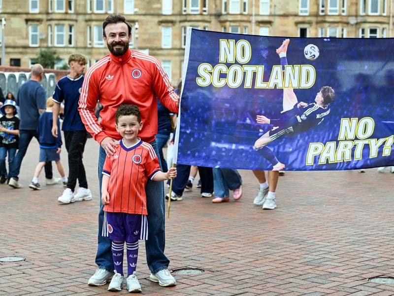Two fans pose with a Scott McTominay flag prior to the game at Hampden Park.