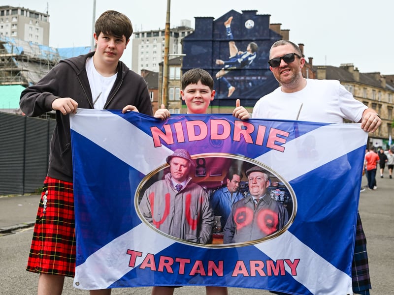 Fans from Niddrie show off their Scotland flag outside of Hampden Park.