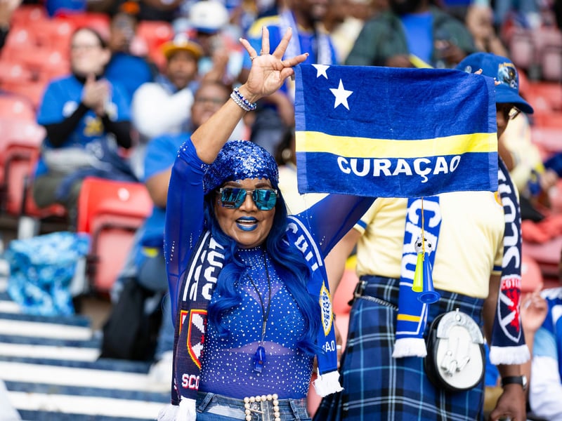 A Curacao fan cheers her team on ahead of the game at Hampden Park.
