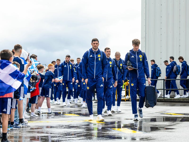 Scott McKenna and Jack Hendry lead the Scotland squad onto the tarmac at Glasgow Airport.