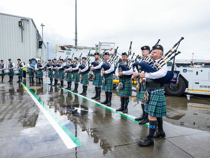 Bagpipers play as the Scotland squad departs for Florida from Glasgow Airport.