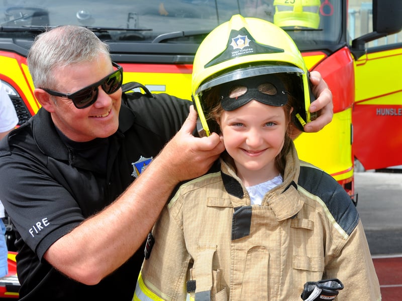 10-year-old Olivia kitted out as a firefighter with the help of Firefighter Richard Sidaway of Hunslet Fire Station 