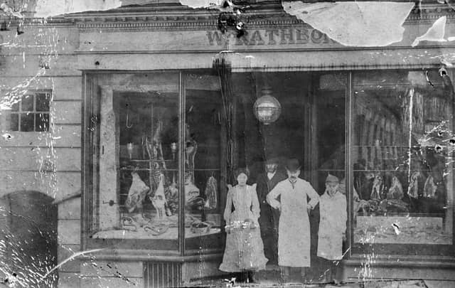 A nostalgic postcard view of a Market Drayton butcher’s shop, believed to be W Rathbone. Staff can be seen standing in the doorway, possibly including Mr Rathbone himself. The undated postcard, likely Edwardian, has only “Market Drayton” written on the back, capturing a glimpse of everyday high street life from over a century ago.