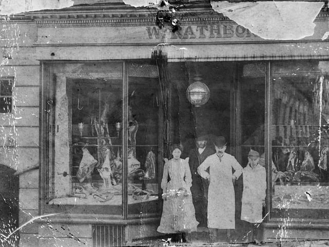 A nostalgic postcard view of a Market Drayton butcher’s shop, believed to be W Rathbone. Staff can be seen standing in the doorway, possibly including Mr Rathbone himself. The undated postcard, likely Edwardian, has only “Market Drayton” written on the back, capturing a glimpse of everyday high street life from over a century ago.
